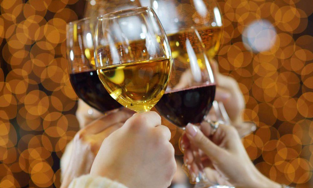 Brindisi con calici di vino bianco e rosso durante le feste