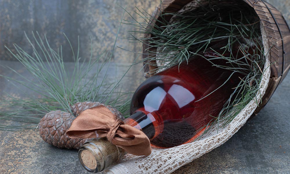 Bottiglia di vino in una confezione regalo natalizia con rametti di pino